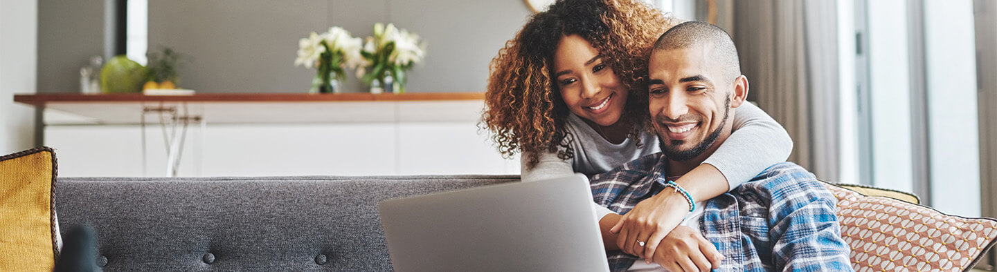 happy couple looking at a laptop together