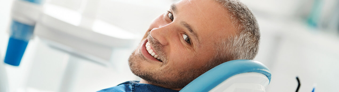 smiling man sitting in a dental chair