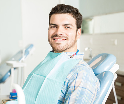 smiling man sitting in a dental chair